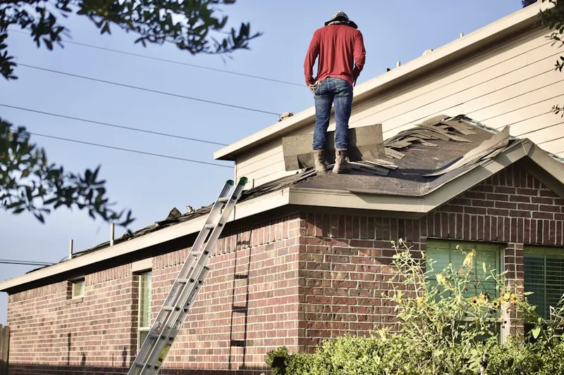 Professional roofer working on a residential roof in Milo